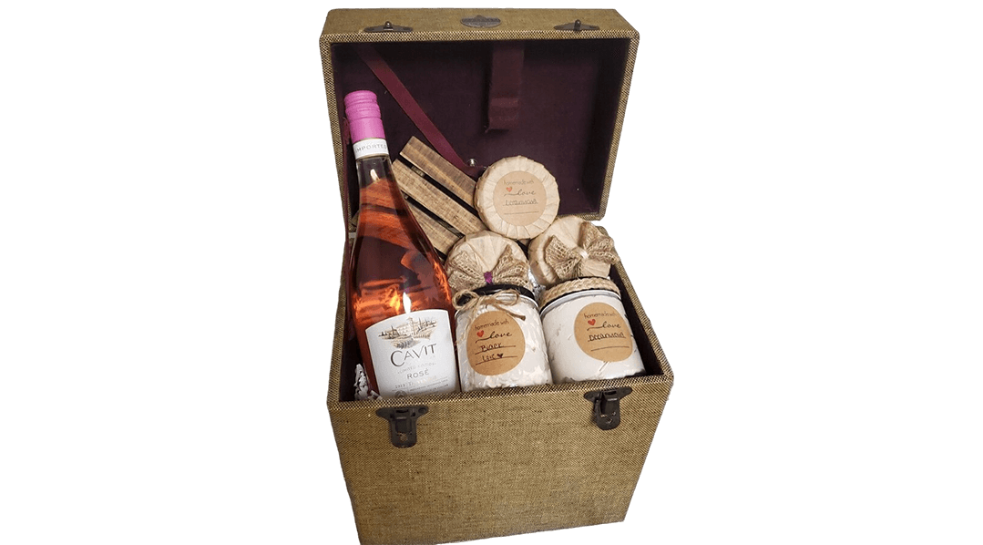 A wooden box with some candles and a bottle of wine