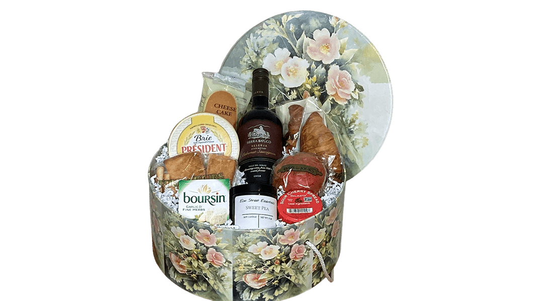 A round gift box filled with food and wine.