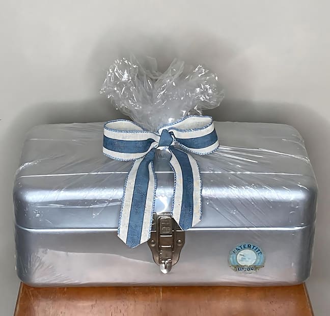 A silver box with a bow on top of it.